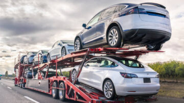 Dec 8, 2019 Bakersfield / CA / USA - Car transporter carries new Tesla vehicles along the interstate to South California, back view of the trailer